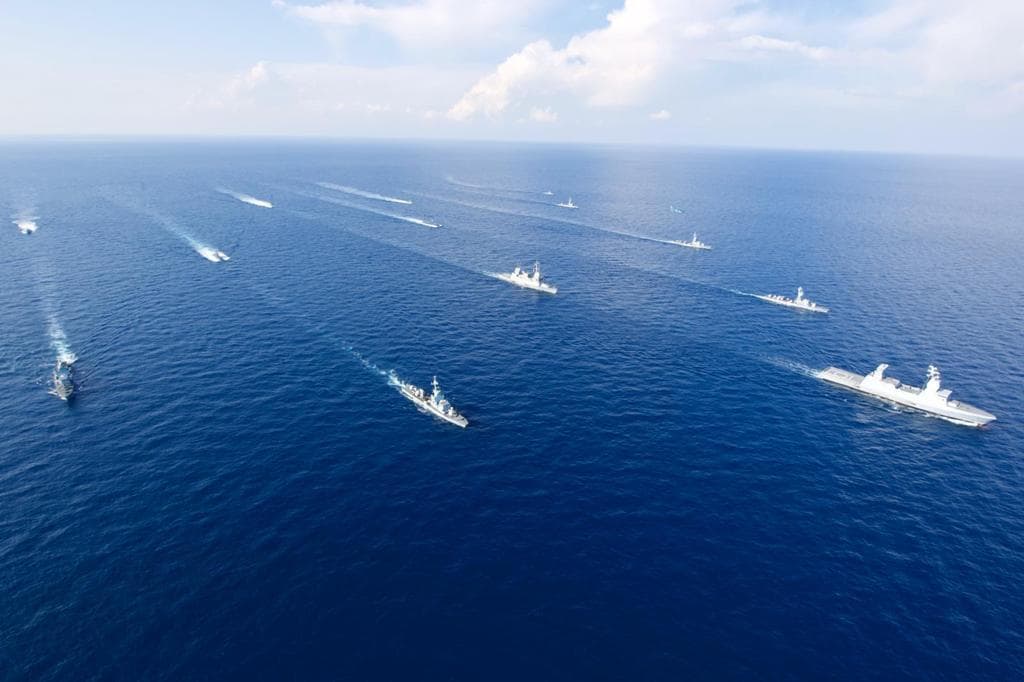 Aerial view of a naval fleet sailing in formation at sea